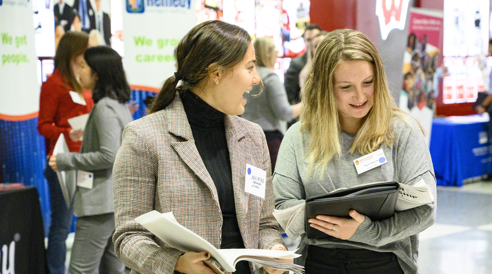 Attendees of the 2019 Career Fair chat in front of employer's booths.