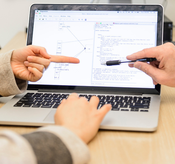 Fingers pointing at computer screen