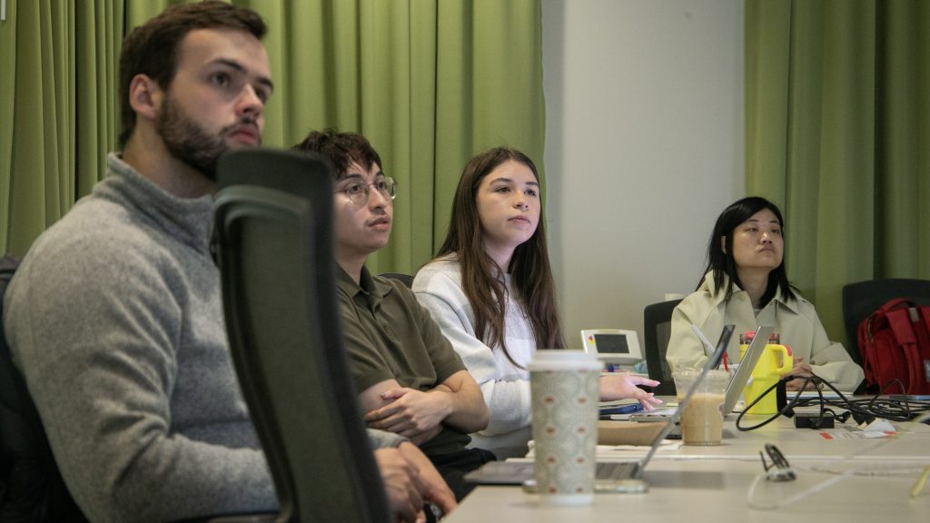 Students around a table with laptops