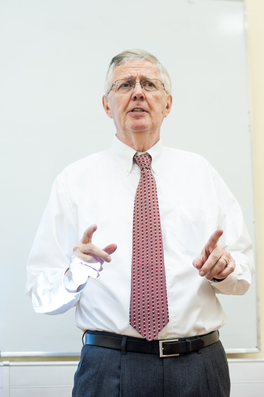 Man with white shirt and tie teaching